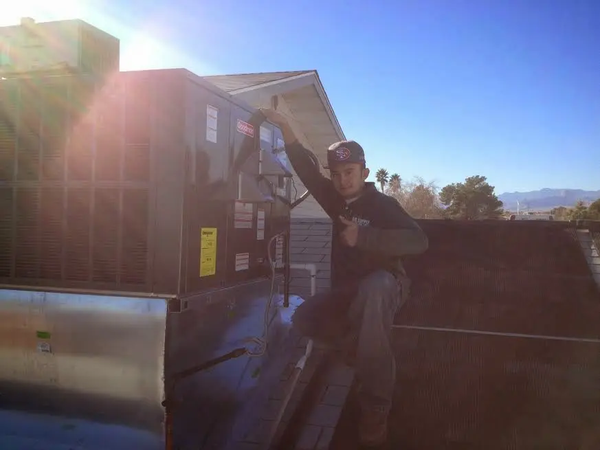 HVAC technician performing Air Duct Cleaning on a rooftop unit in Caledonia
